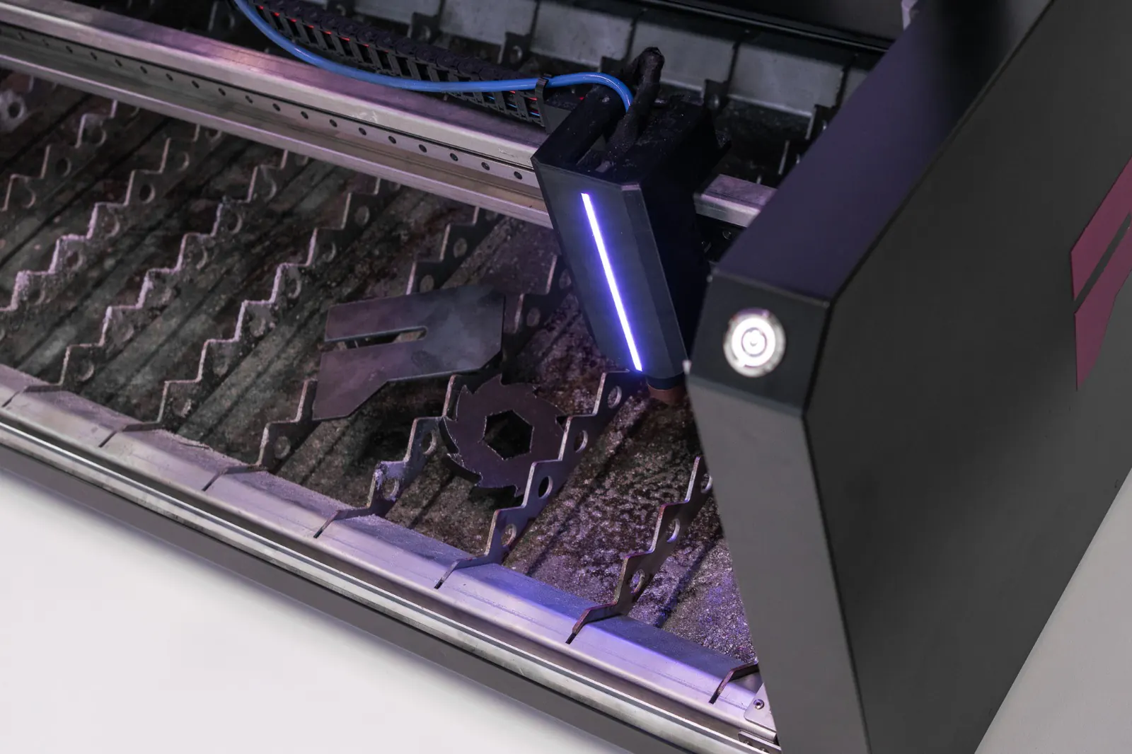 Plasma torch passing over freshly cut steel parts